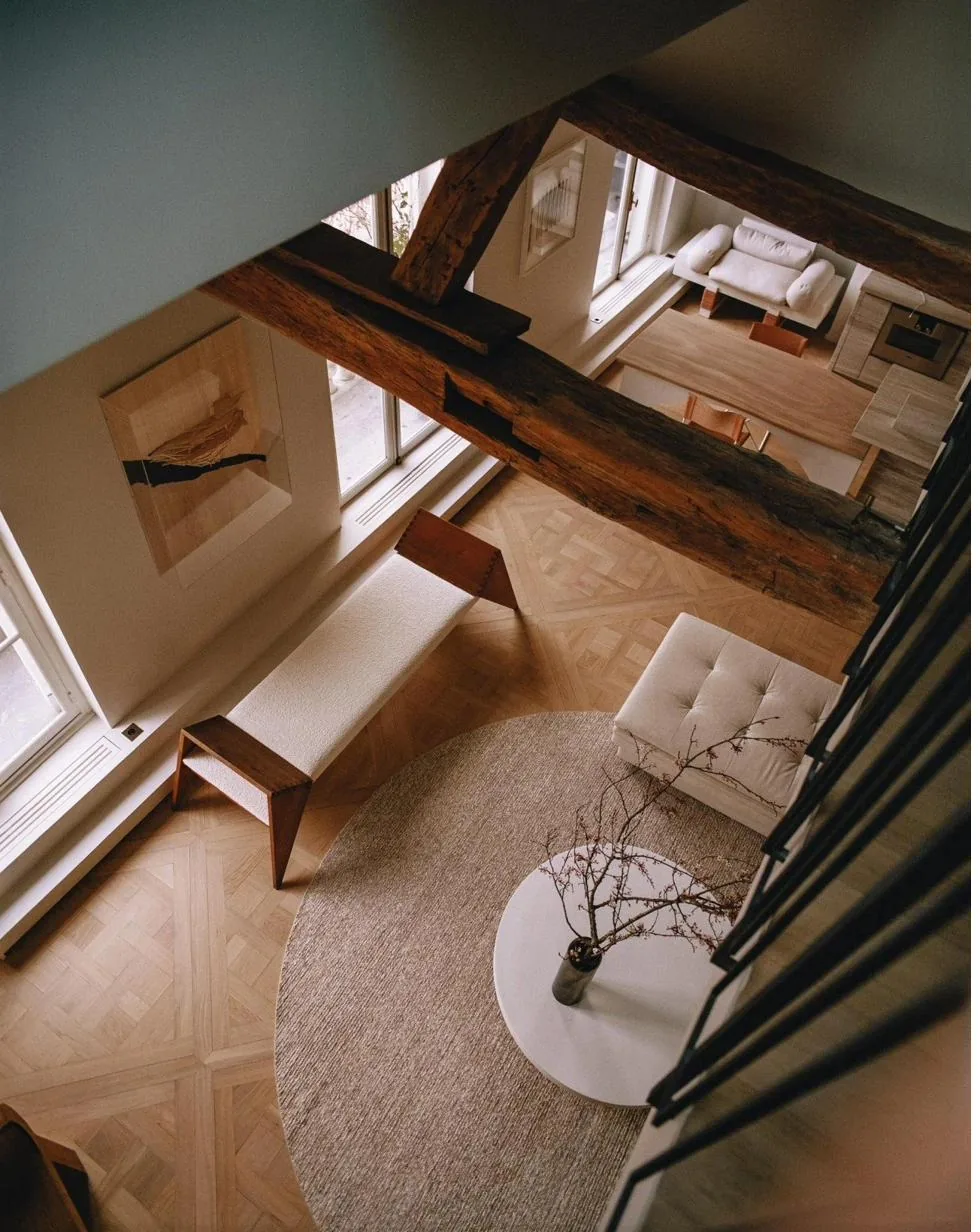 Interior residencial con vigas de madera vista desde un nivel superior